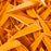 Closeup of many sunset orange AAE Elite Plastifletch 1.6-inch vanes with Ten Zone Archery logo watermark