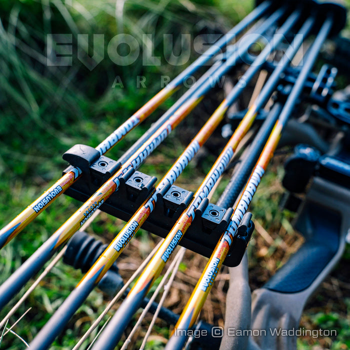 Tomahawk .005 arrows by Evolusion Arrows from Ten Zone Archery in a bow quiver of a compound bow lying on green undergrowth. Image copyright Eamon Waddington.